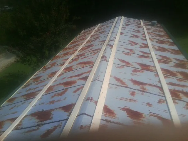 Rusted metal roof panels with new wood purlins before replacement — Storm Damage Roof Repair in Scarsdale by Roofing Brothers