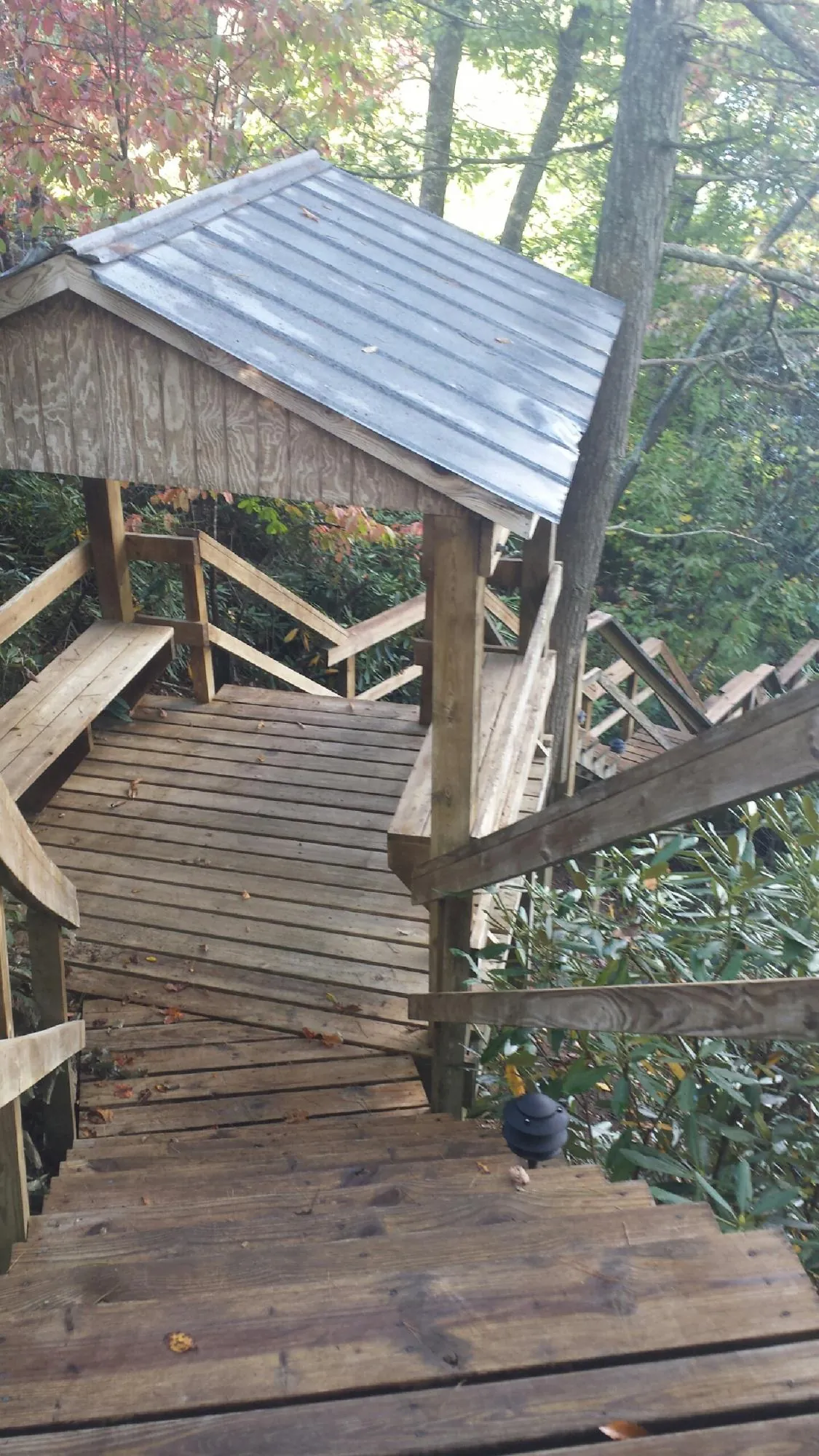 Metal roofed shelter over wooden steps on a wooded walkway — Skylight Repair & Installation work by our crew in Scarsdale