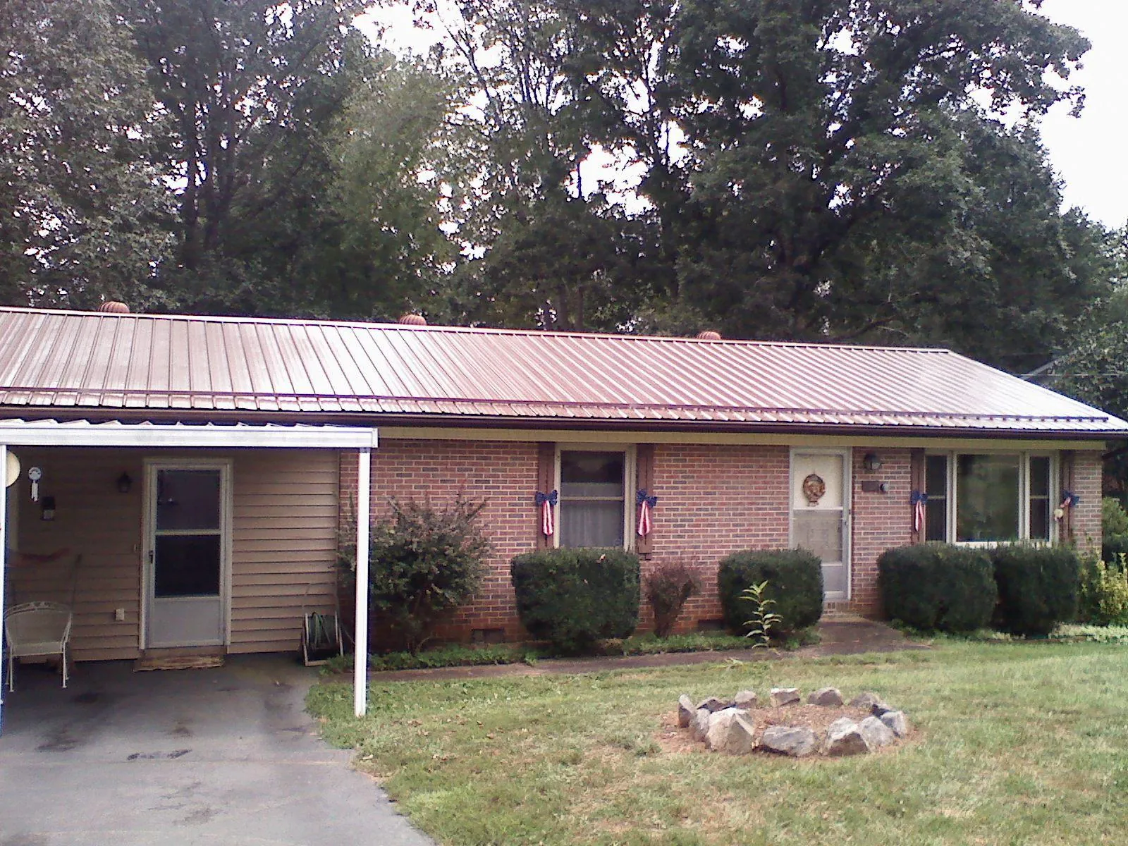Bronze metal roof and carport on a brick ranch home — Roof Repair work by our crew in Scarsdale